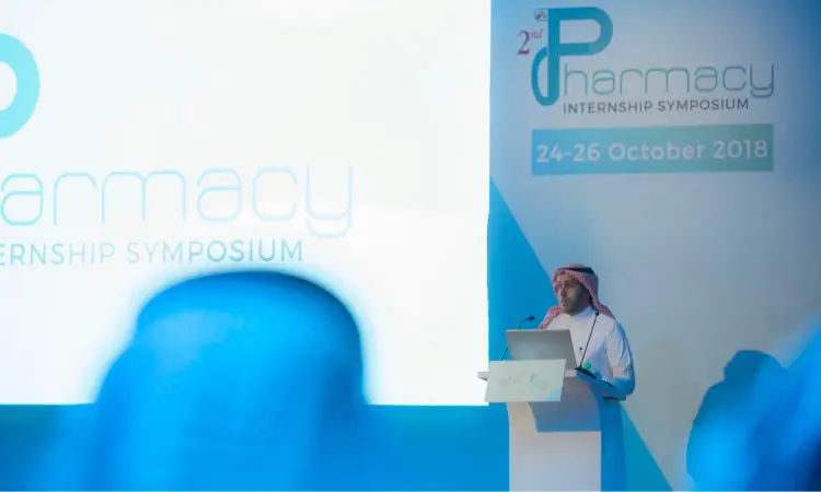 رجل يرتدي الغترة السعودية والعقال والبشت السعودي، المتحدث الكبير على المنصة خلال فعاليات الندوة الثانية للامتياز لطلاب الامتياز، التي نظمتها كلية الصيدلة في جامعة القصيم خلال الفترة من 24 إلى 26 أكتوبر 2018م. تم اختراعه لشاشة كبيرة تحمل الشعار وهي شركة متخصصة فقط.