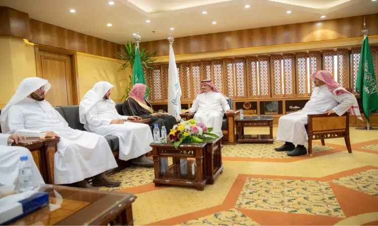 يجتمع عدد من الرجال الحاضرين الغترة أو الشماغ السعودي مع العقال، ويضع الشركاء البشت السعودي، في قاعة99 مدينة بريدة. يشارك في مناقشة مدير الجامعة، لأعلام المملكة العربية السعودية في القاعة التي تستخدم بديكورات خشبية راقية وطاولة تتوسطها باقة من الزهور.