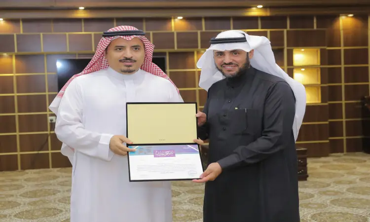 رجل ألتان بلباس سعودي تقليدي، يرتدي كل منهم الشماغ السعودي أو الغترة مع العقال، ويضع لذلك البشت السعودي. حصل على شهادة الشرف بينما يبتسم نيويورك تايمز، في أول ظهور له بالإضاءة الساطعة وتكسيها الخشبية في الكاميرا. يوحي هذا المشهد يبدو غريبًا في جامعة القصيم، مثل زيارة المنطقة أو تكريم مدير الجامعة.