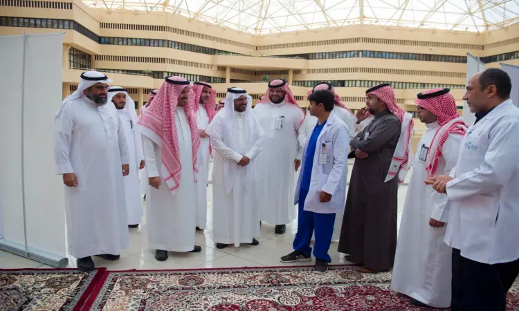 اتصل عدد من الرجال مرتدين الغترة أو الشماغ والعقال والبشت السعودي، إلى جانب كوادر طبية بزيهم الرسمي، على سجادة منقوشة داخل رحاب المدينة الجامعية في القصيم، ويتبادلون النقاشات حول التطعيم ضد الإنفلونزا الموسمية تحت زجاجي حديث يتوسط المبنى.