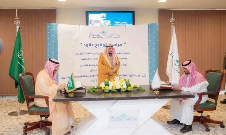 اجتمع ثلاثة رجال بزي سعودي تقليدي يتكون من غترة أو شماغ وقال وبشت سعودي، وذلك لتوقيع عقد رسمي في جامعة القصيم، حيث وضعت الوثائق والزهور على الطاولة. يأتي هذا المراسم لتسليط الضوء على خدمات حركة الطلاب المقدمة لكلية العلوم والآداب بالبكيرية، وسط أعلام المملكة العربية السعودية وشعار الجامعة الرسمية.