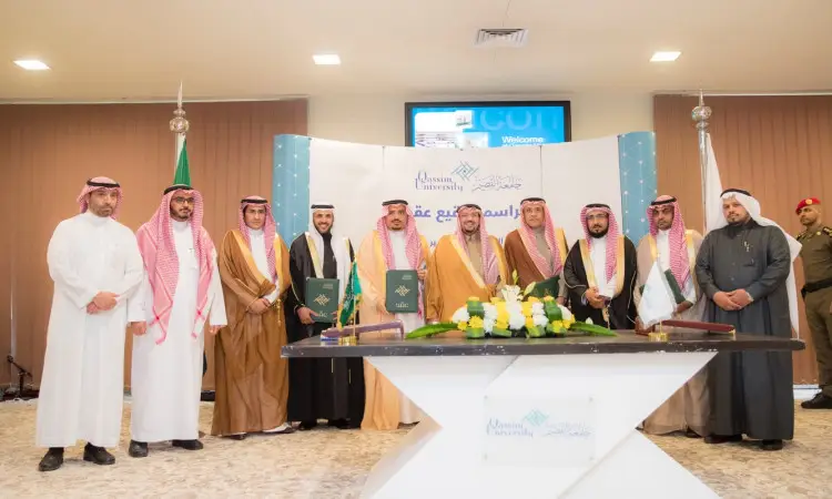 الاتصال مجموعة من الرجال مرتدين الغترة أو الشماغ السعودي مع العقال والبشت السعودي في حفل رسمي أمام طاولة مزينة بالزهور و تحمل شعار جامعة القصيم، وذلك احتفاءً بتوقيع عقدين لخدمة الطالبات لكلية العلوم والآداب بالبكيرية.