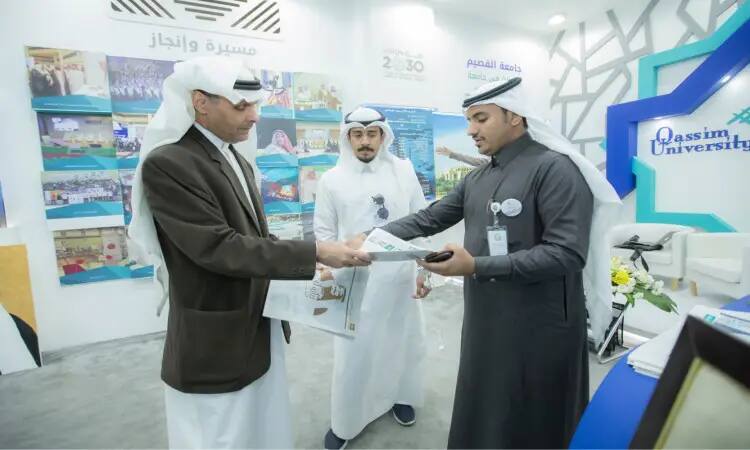 كل ثلاثة رجال تضررت الغترة أو الشماغ والعقال والبشتاء السعودي أمام جناح جامعة القصيم خلال فعاليات الجنادرية 33، حيث يقوم أحد بتسليم نشر تعريفية لزميله. الاشتراك في الملصقات التجنيدية وإنجازات الأكاديمية.