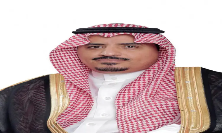يرتدي الرجل ثوباً تقليدياً سعودياً، وبشتاً سعودياً باللون الأسود مزيناً بالتطريز الذهبي، بالإضافة إلى شماغ سعودي أحمر وأبيض مع عقال، ويمثل منسوبي الجامعة. يظهر في الصورة وهو يسكن إلى الكاميرا وخلفه الأبيض.