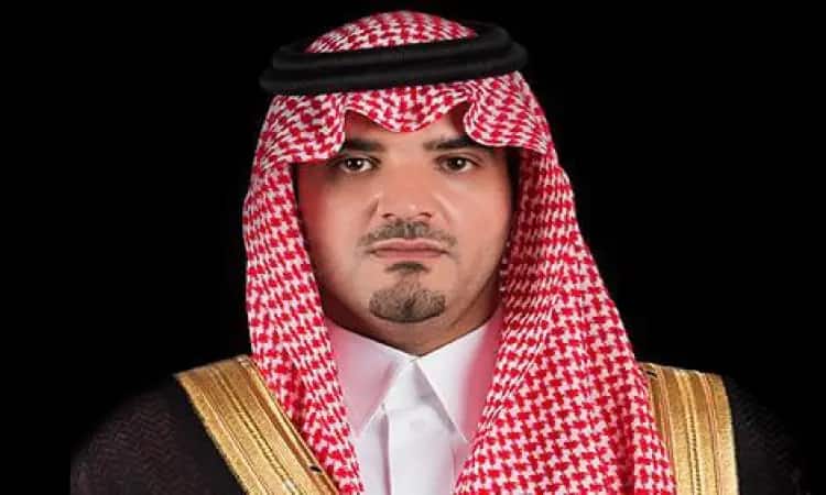 Standing confidently against a simple black background, a distinguished gentleman wears a red and white Saudi shemagh, complete with a black headband, and is draped in an elegant Saudi bisht embellished with gold. His elegant appearance reflects the utmost excellence and sophistication, befitting the values of Qassim University.