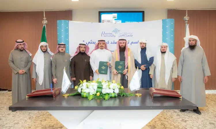 القطة جمع من الرجال مرتدين الغترة أو الشماغ السعودي مع العقال والبشتت السعودي، مصطفين جميعاً القاعة، حيث يلتقطون صورة جماعية خلال مراسم الرجال توقيع في جامعة القصيم. وتبدو على وثائق وأعلام الجامعة، وذلك احتفاءً بتدشين كرسي القرآن في علوم القرآن للأطفال.