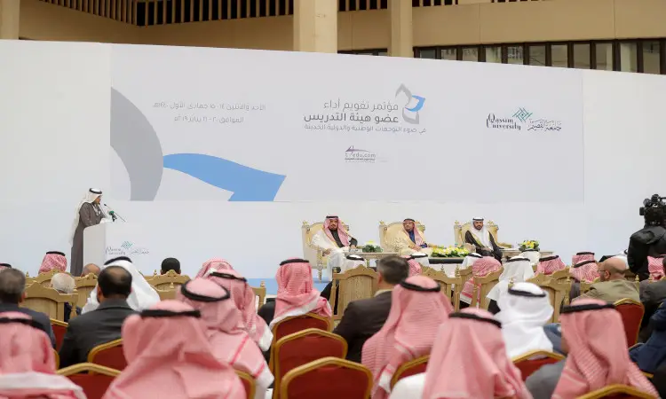 يُقام مؤتمر دوري في الهواء الطلق بحضور حضور الرجال الشماغ أو الغترة السعودية مع العقال والبشت السعودي. يجلس ثلاثة كبار على المنصة تحت الجلد وتحمل نصًا باللغة العربية وشعارات جامعة القصيم، بينما يلقي أحدهم كلمته على منصة الخطابة.