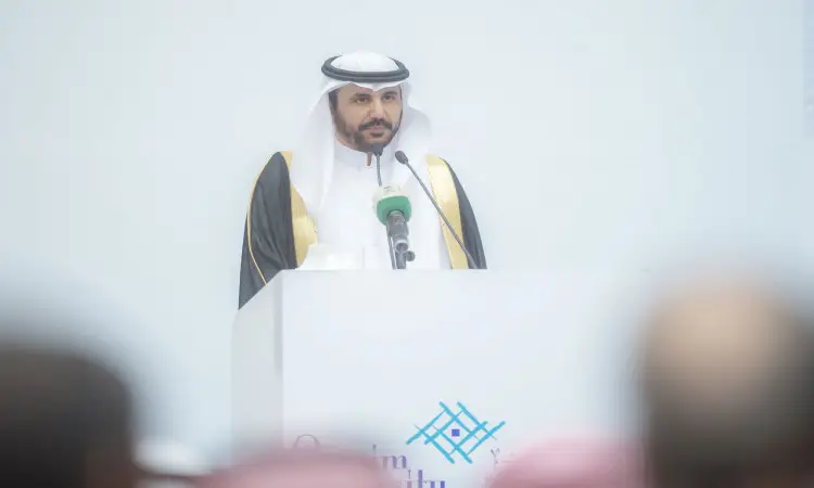 رجل الاتصالات يرتدي الغترة السعودية والعقال، متشحًا بالبشت الرسمي السعودي، المتحدث الرسمي منبر الأبيض بعدة ميكروفونات خلال المؤتمرات الدولية في جامعة القصيم، للحضور بشكل ضبابي في مواجهة التحديات، بينما مضاءة بشكل خفيف للعكس للجميع وأكاديمية.