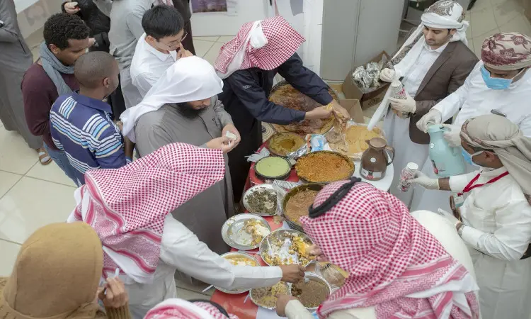 يجتمع مجموعة من الرجال مرتدين الغترة أو الشماغ السعودي مع العقال والبشت السعودي، ومن بينهم طلاب القلم، حول مائدة تزخر بأصناف متعددة من المأكولات من خلال فعاليات "مهرجان تراث الشعوب" في جامعة القصيم، حيث يتبادلون الزراعة ويحتفون بحضارات نفقتهم في ظل مراعاة روح الألفة والتنوع الثقافي.