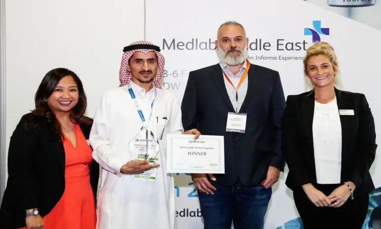 يجتمع أربعة أشخاص خلال جزء التكريم. ويظهر الرجل الثاني من إيفان مرتديًا الغترة والعقال والبشت السعودي، ويحمل بيده درعًا وشهادة معتمدة ضمن معرض دبي الدولي للمختبرات (ميدلاب 2019)، فيما يبتسم بقية الحضور إلى الجانب الأمامي وتحمل شعار ميدلاب الشرق الأوسط.