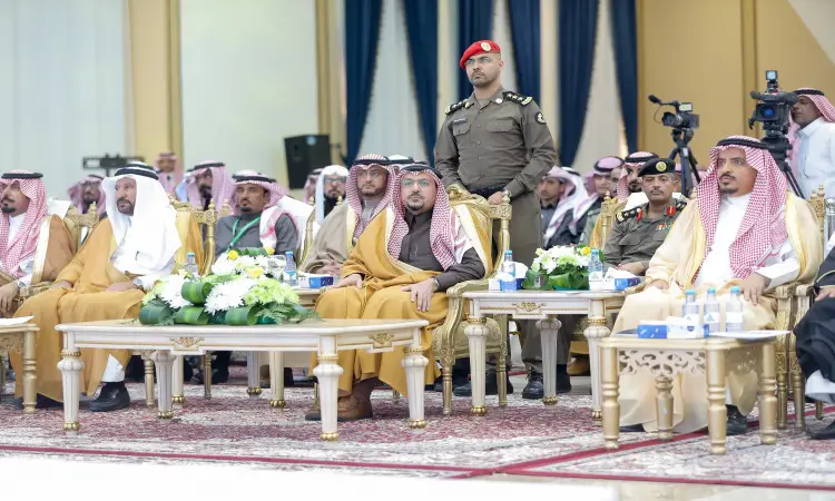 يجلس عدد من الرجال مرتدين الغترة أو الشماغ والعقال، يجلسون بجانبهم بالبشت السعودي والزي العسكري، على كراسٍ مشهورة ضمن فعالية المجتمع في جامعة القصيم. وتزين الجداول أمامهم تنسيقات من الزهور الطبيعية وعبوات مياه الشرب. شارك في تسليط الضوء على بعض الأشخاص الواقفين خلال حملة الجامعة.