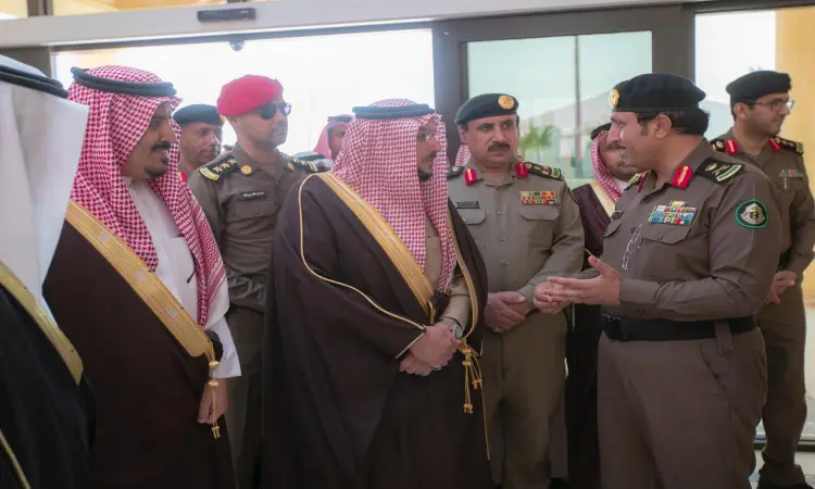 مجموعة الاتصال من الفريق السعوديين وضباط الشرطة، يجتمعون تحت الغترة السعودية أو الشماغ والقائل، وأخيراًون البشت السعودي، مجتمعين داخل مدرسة القيادة التعليمية في جامعة القصيم. ويظهر وهم يحادثون بشكل رسمي من الباب المفتوح.