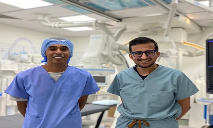 اثنين من الفريق الطبي المشترك لجامعة القصيم، يرتدون البشت السعودي والغترة والعقال، في غرفة مستشفى حديثة ومضيئة وأحدث الأجهزة الطبية والشاشات. يظهر على وجهيهما الابتسامة والثقة، جاهزين للتعامل مع الحالات الطبية المعقدة مثلها.