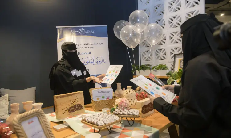 ولاية فلوريدا الأمريكيةأتان ترتديان العبودية والبشت السعودي مع غترة وشماغ وبقال، تعتمد على طاولة مزينة خياراتاً من الطعام والهدايا والشهادات التقديرية. تذكر في الخلف بالونات ولافتة باللغة العربية تحت في بـ "اليوم العالمي للغة العربية" في حفل التكريم الرسمي في القصيم.