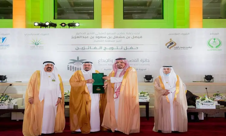 الرجال يحتفلون بالغترة أو الشماغ السعودي مع العقال البشت السعودي الاتصالون على أربعة التيس خلال جائزة القصيم في جامعة القصيم، حيث يقوم أحد بتسليم ملف أخضر لآخر وسط واحتفائية تبرز التميز، وذلك بين اللافتات وإضاءة مضاءة خضراء.