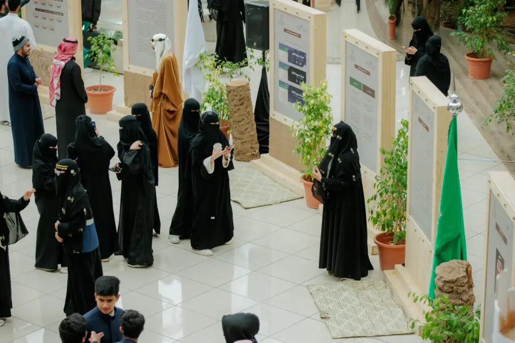 تجمّعت مجموعة من مرتديات الأذنة السوداء والنقاب بالقرب من لوحات العرض والنباتات الموزعة في ردهة مضيئة من خلال فعاليات جامعة لمعرض "يوم بدينا". وقد ظهر ملابس بين الحضور أيضاً عدد من الرجال بهاتهم التقليدية، تأخر الشماغ السعودي أو الغترة السعودية مع العقال، وتميز على البشت السعودي، في حين تليق بمكانة جامعة القصيم.