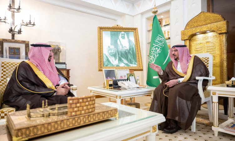 يرتدي رجلان سعوديان ويرتدون الغترة والشماع والعقال وكذلك البشت السعودي، متقابلين في قاعة فخمة تبرز فيها الزينة الذهبية، وبجانبهم علم المملكة العربية السعودية وقيادة الدولة. ويشهد منهم الدكتور محمد الشارخ، رئيس الجامعة، يتحاور مع صاحب السمو أمير منطقة القصيم في رسم رسمي لمكان جامعةها الوطنية.