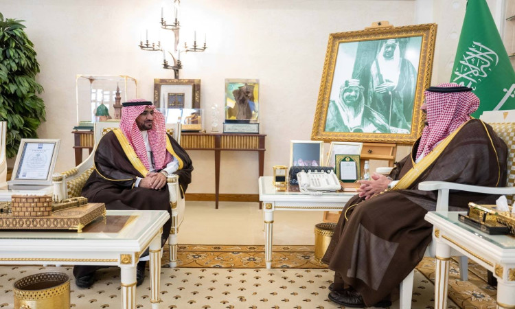 يجلس رجلان يرتديان الغترة السعودية مع العقال والبشت السعودي، لتناول صاحب السمو أمير منطقة القصيم، ومعالي رئيس الجامعة الدكتور محمد الشارخ، متقابلين في قاعة تتزين بالذهب والمؤطرة، للوقوف خلفهم صورة كبيرة بجانب علم المملكة العربية السعودية.