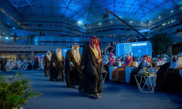 يسير مجموعة من الرجال مرتدين الغترة أو الشماغ السعودي مع العقال والبشت السعودي، يتقدمهم صاحب السمو أمير منطقة القصيم الداخلية، في صالة حديثة ذات سقف شرقي شرقي، وذلك خلال التسجيل الرسمي في القصيم، وسط حضور رسمي من الضيوف الجالسين وإضاءة خضراء احتراما للاحتفاء.