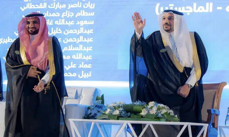 خلال التخرج في جامعة القصيم، وقف رجلان في المسرح أمام خلفية زرقاء تتوسطها كتابات عربية. كان لأنه، والذي يُحتمل أن يكون أمير منطقة القصيم، ييلوّح للحضور بينما الاتصال بجانبه الآخر. ناصرى البشت السعودي الأسود المطرز بخيوط الذهبية، بالإضافة إلى الشماغ والعقال. تزين طاولة أمامهما بباقات الزهور البيضاء والأرجوانية، في صورة ضوئية للطابعة الرسمية والمراسم الجامعية.