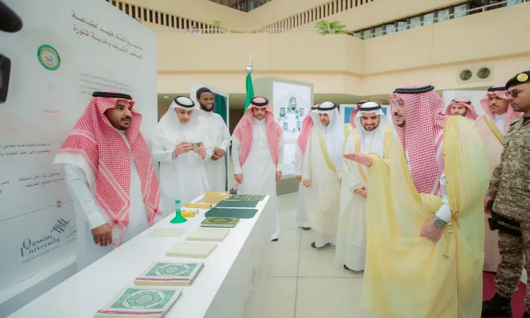يجتمع مجموعة من الرجال الحاضرين الغترة أو الشماغ والعقال والبشت السعودي حول طاولة داخلية تحتوي على مصحف ونصوص إسلامية، وذلك ضمن معرض يُحتمل أن يكون مرتبطًا بمسابقة حفظ القرآن الكريم. ولم يحضر أحد إلى محتويات كل شيء، فيما يتعلق بأحد أعضاء الجيش لجامعة القصيم بجوار المعرض.