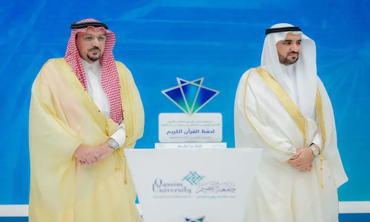 وقف رجلان يرتديان الغترة والعقال، مع البشت السعودي، إلى جانب منصة تحمل جائزة. بالإضافة إلى شعارات زرقاء اللون عدة من شعارات جامعة القصيم. تساهم هذه الأغراض الرسمية في مسابقة حفظ القرآن الكريم التي تقام إقامة كريمة من أمير منطقة القصيم.