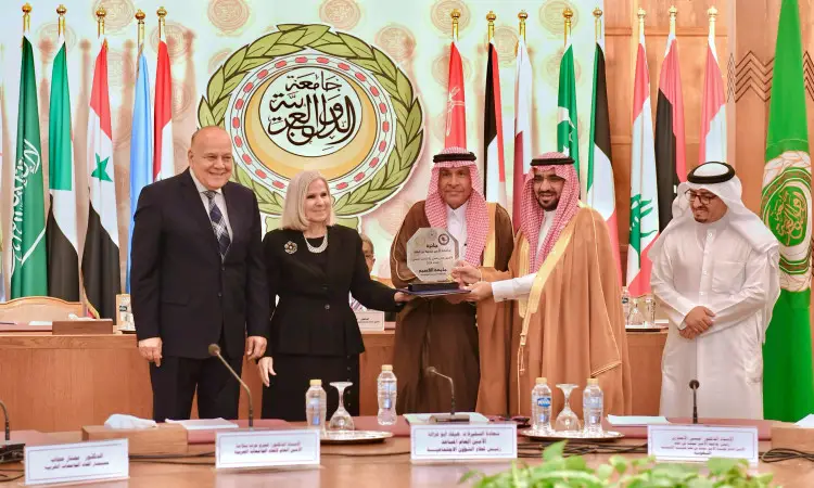 مجموعة الاتصالات من المهام في زي رسمي تضم الغترة أو الشماغ السعودي والعقال مع البشت السعودي حيث يوجد، مبتسمين أثناء تقديم جائزة جامعة الأمير محمد بن فهد لأفضل إنتاج علمي. لإعداد أعلام الجامعة وشعار جامعة الدول العربية، في مشهد يسوده الطابعة الرسمية والهيبة الأكاديمية.
