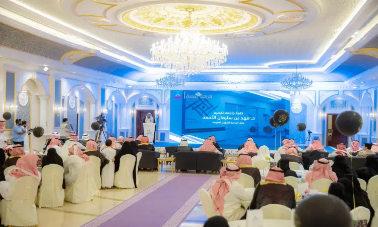 ويقام الحدث الرسمي في قاعة فاخرة مزينة بالثريات، حيث يحضر الحضور وهم الحضور الزي السعودي الرسمي الذي يشمل الغترة أو الشماغ مع العقال والبشت السعودي، على موائد احتفاء بتخريج الدفعة الأولى من جامعة القصيم. يتصدر المنصة الرئيسية، وخلفيه شاشة العرض باللغة العربية الفرنسية.