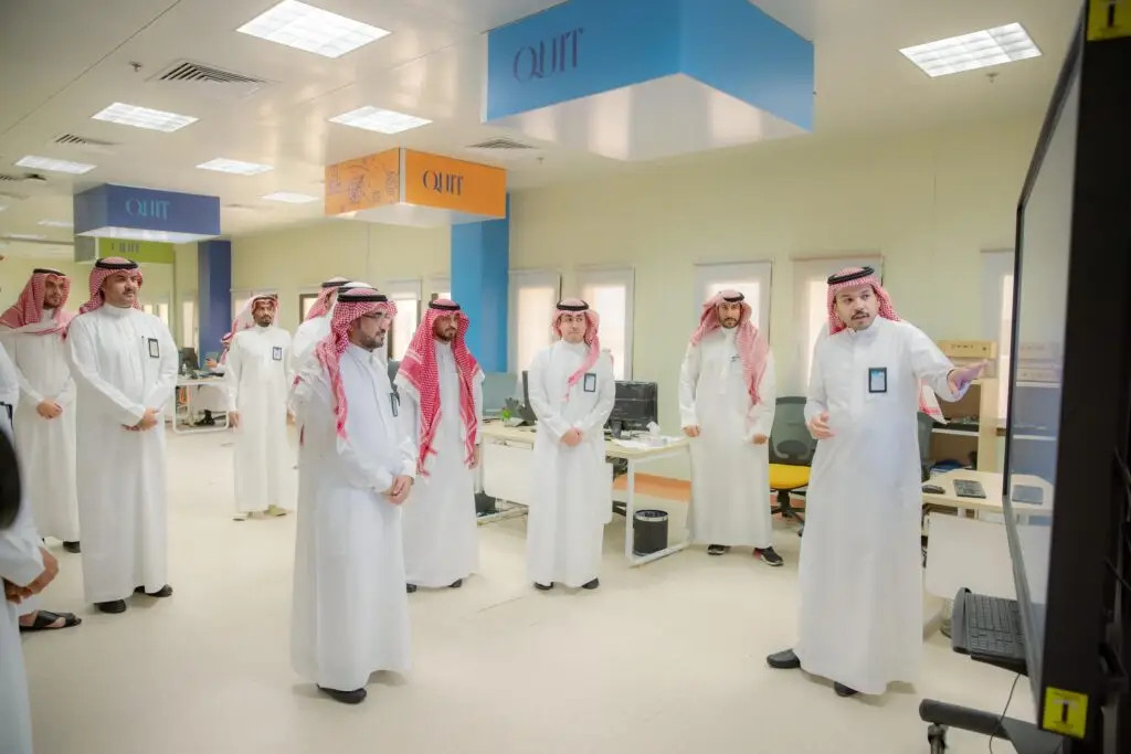 كل مجموعة من الرجال مرتدين الزي السعودي الرسمي، تشمل الغترة أو الشماغ والعقال، وبعضهم يرتدون البشت السعودي، يتقدمون بهم رئيس الجامعة، في أحد التلاميذ؛ حيث يقوم أحد خيارات خيارات المعلومات بالتصميم الجديد للموقع الإلكتروني على شاشة العرض. وتزين لوحة المفاتيح لافتة معلقة معلقة من بينما تكتمل منظومة الضيافة من أجهزة الحاسب الآلي المصطفة على الجداول.