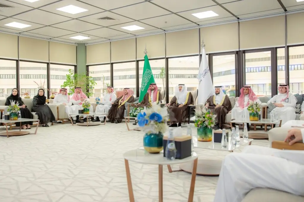 A number of men and women gathered formally in the designated hall in Qassim, where the Digital Government Authority was among the attendees. The men wore the Saudi ghutra or shemagh with the traditional Saudi aqal and bisht, while the university was decorated with Saudi Arabian flags and floral arrangements for worship. The next window overlooked the city's outer buildings, giving the meeting a distinctive character befitting its stature and importance.