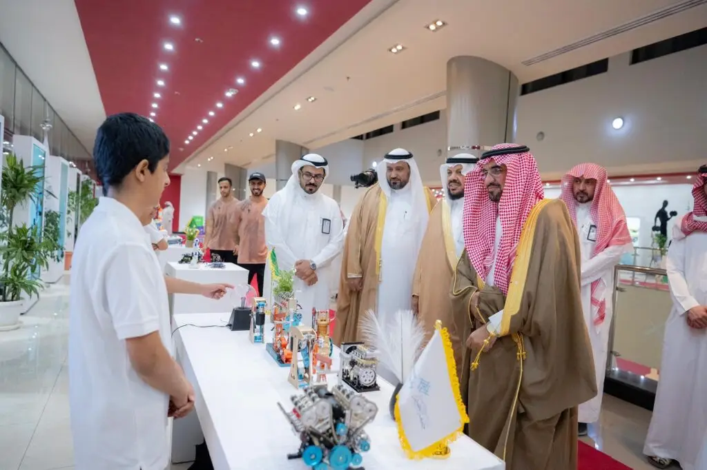 يجتمع عدد من الرجال بلباسهم الأصلي المميز، ولت غترة أو شماغًا سعوديًا مع عقال وبشت سعودي، في رحاب جامعة القصيم، حيث يشاهدون باهتمام أحد الحضور حيث يعرض اختراعات روبوتية على طاولة داخل قاعة اجتماعات فخمة. يعاني بعض الحضور من الابتسامة والتفاعل مع العرض المُقدَّم.