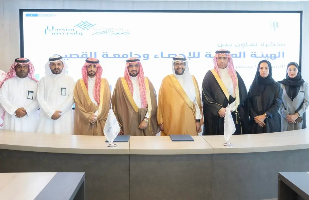 A contact group of men in traditional Saudi attire made up of Ghattar, Shemagh and Saudi Bisht, gathered in front of a text screen in Arabic, thanks to the segmentation of the children's image by signing a strategic partnership or research event at Al-Qassim University.