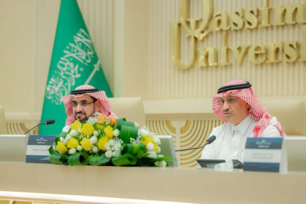 يرتدي رجلان الزي السعودي الرسمي الامتداد في الغترة أو الشماغ السعودي مع العقال، بالإضافة إلى البشت السعودي، على طاولة الاجتماع المستقل بميكروفونات وتزينها باقة من الزهور الصفراء البيضاء. ساهم في علم الخلفية المملكة العربية السعودية وشعار جامعة القصيم. من كشف أن يكون هذا الشخصان من قيادات الجامعة.