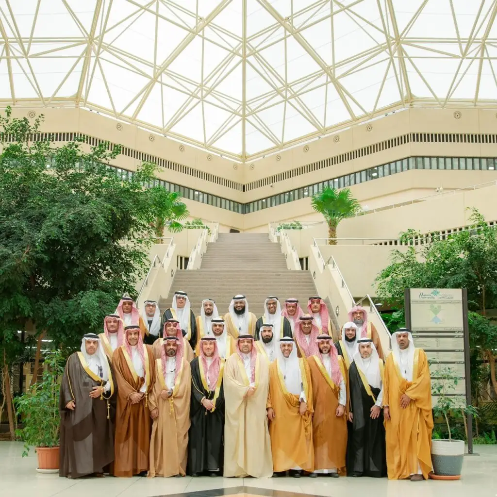 اجتمعت مجموعة من الرجال وهم وهم الغترة أو الشماغ السعودي مع العقال، وبعضهم يرتدي البشت السعودي الرسمي، إحدى قاعات جامعة القصيم. جاء هذا التجمع في إطار الاجتماع، حيث وقف الحضور أمام السلم والنباتات الداخلية بالنباتات الخضراء ويتوجن المكان كأس زجاجي تجاري، في المركز الثقافي الوطني والرسمي للجامعة.