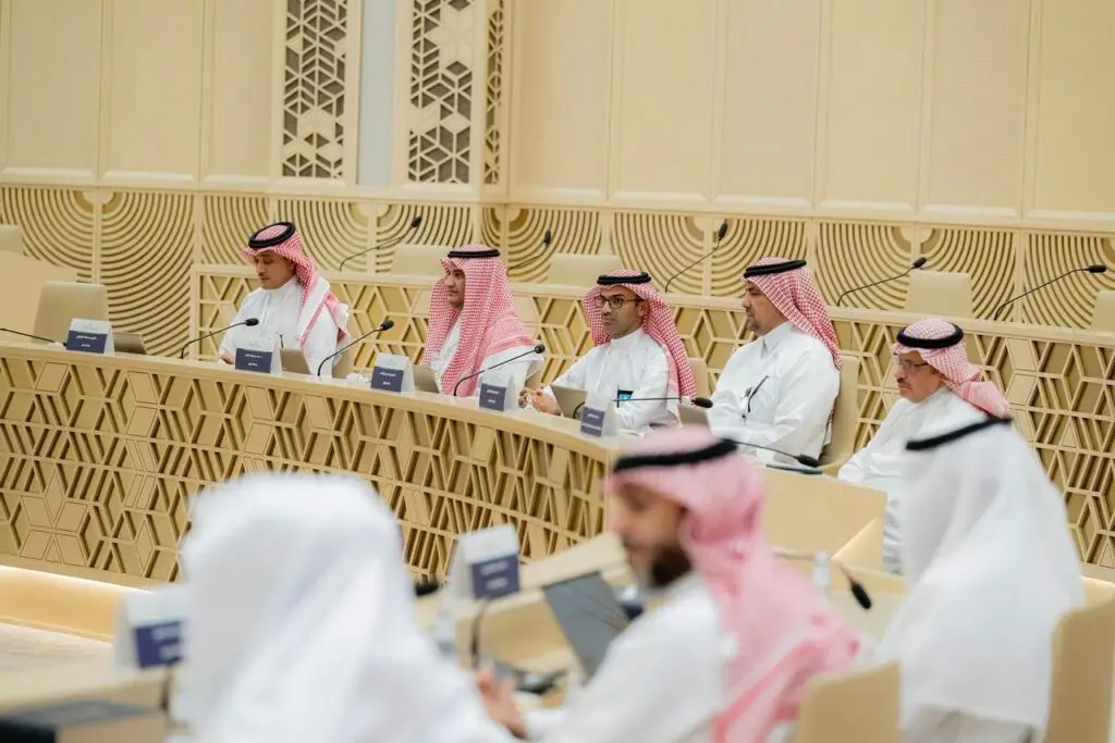 اجتمع وكلاء الجامعات السعودية الحديثة في القاعة في القصيم، وهم حاضرون البشت السعودي فوق الثياب، ويضع كل منهم الشماغ السعودي أو الغترة والعقال بدقة للأطفال. جلسة الحضور باهتمام أمام أجهزة اللابتوب والميكروفونات الموضوعة على الجداول، أثناء إضافة الزخارف الهندسية الرائعة خلفهم طابع مميز يليق بمكانة الجامعة.