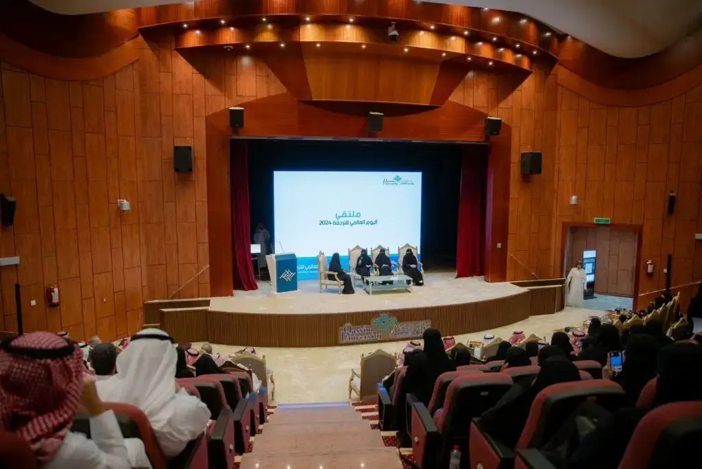 تقام فعالية خاصة بمناسبة اليوم العالمي للترجمة في الدورة المتخصصة ذات جدران مكسوة بألواح خشبية. ويجلس على المنصة عدد من المقررين من كل اللغات، توق الغترة السعودية أو الشماغ والعقال مع البشت السعودي، أمام شاشة تعرض النصوص تلقائياً باللغة العربية، بينما يستمع الحضور باهتمام وجدية للأطروحات المقدمة في جامعة القصيم.