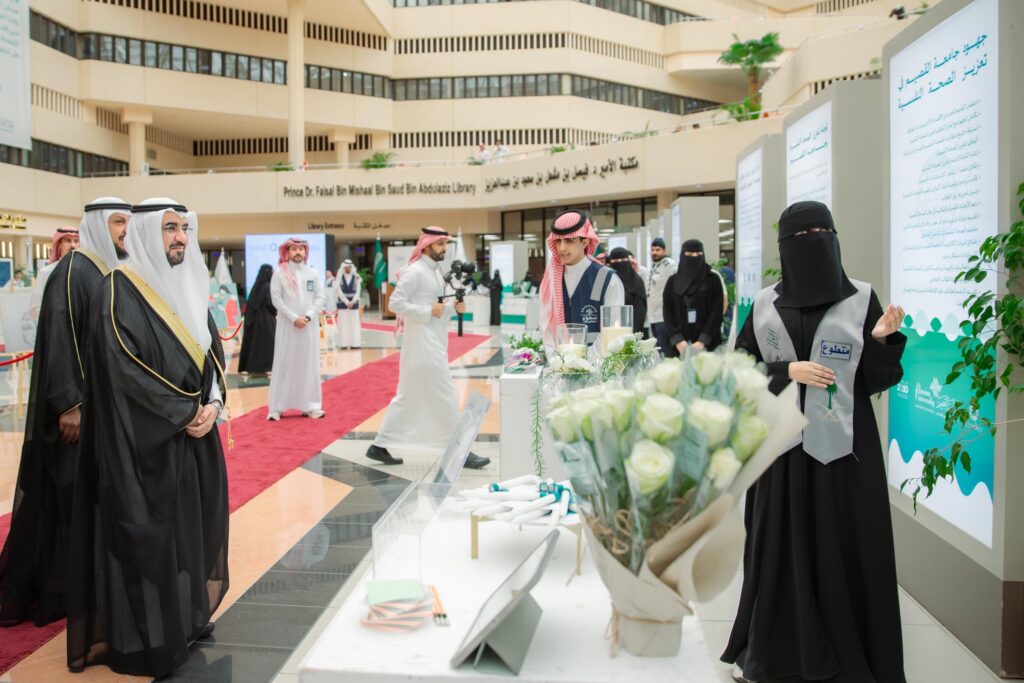 تتشرف مجموعة من الزوار الحديثين بارتداء الغترة والعقال والبشت السعودي، مريح داخل معرض "آمال" المُقام أحد المباني التي تتزين باللافتات العربية. وقد توقفت إحدى وحدات الرعاية الصحية بجانب شاشة العرض المزخرفة بورود جديدة، في مشهد يُجسّد جهود رعاية الصحة النفسية تحت رعاية رئيس جامعة القصيم.