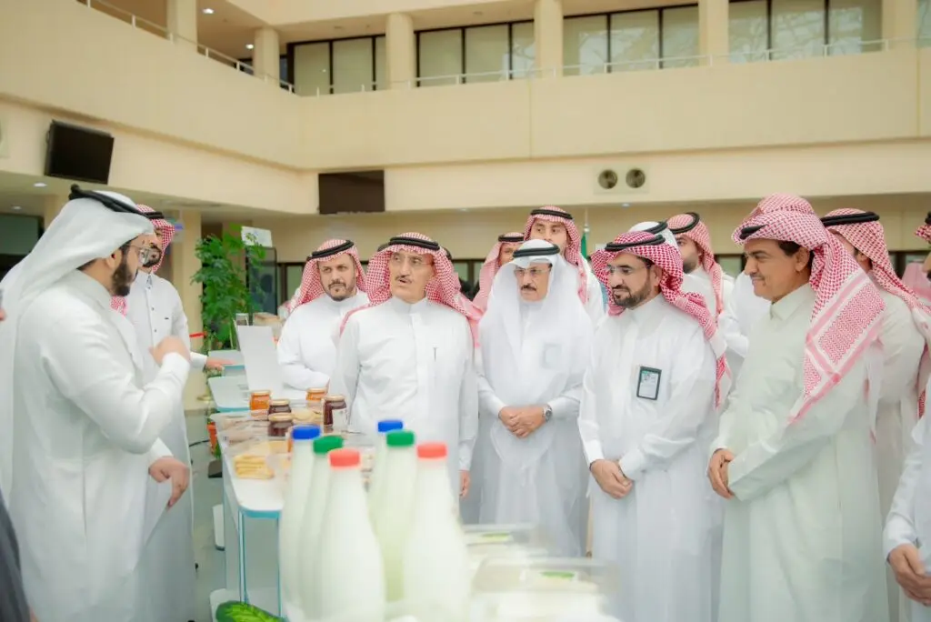 مجموعة تحتوي على رجال الزي السعودي الأصلي، ومنهم رئيس الجامعة، الاتصالون حول طاولة داخل عرض على عدد من المنتجات مبنى حديث. يتجمعون للنقاش حول الشراكات المجتمعية تتعاون مع الهيئات الحكومية، حيث لا يقوم أحد بالتحدث بالإشارة خلال حديثه فيما يستمع باهتمام.