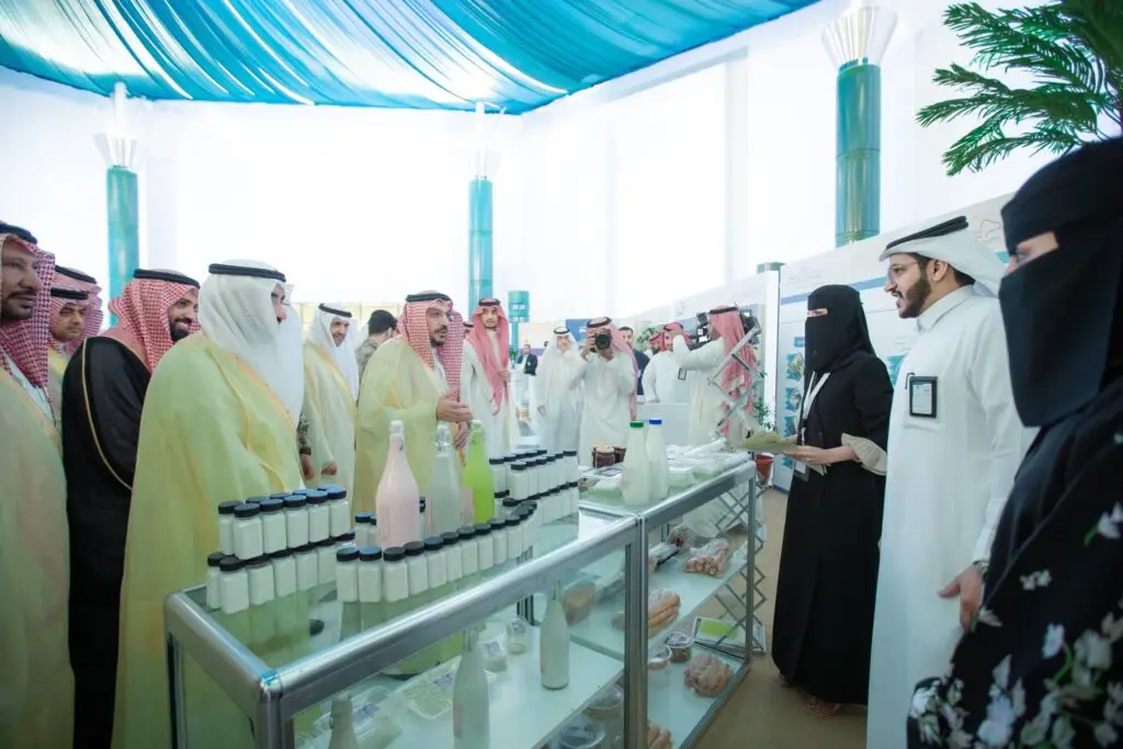 يجتمع عدد من الرجال مرتدين الشماغ أو الغترة السعودية التقليدية، والسيدات مرتديات العباءات، حيث يلزم تحتوي على مشروبات كافية وأصناف متنوعة، وذلك ضمن معرض داخلي يُقام خلال اللقاءات العلمية الدولية للإبل، حيث سيجتمع بينهم نقاش بنّاء تحت سقف كله بقماشين باللون الأزرق الأزرق.