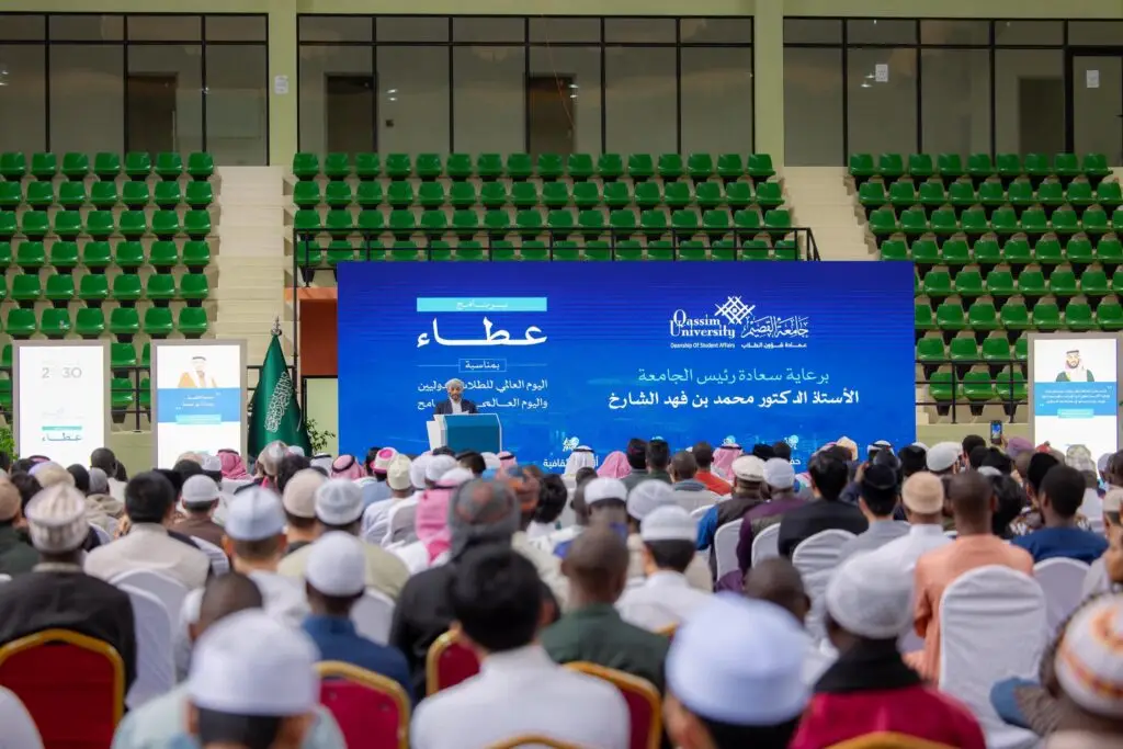 وحضروا جمعٌ غفير من الحضور، غالبهم من الرجال مرتدين والأصلية ومنهم من تأخر الشماغ أو الغترة السعودية، إذ يجلسون في مواجهة منصة يتوسطها شاشة زرقاء تعرضون نصاً باللغة العربية حول "برنامج عطاء"، وذلك ضمن فعالية طلابة يُشرف عليها رئيس جامعة القصيم، ويقومون في صالة مقاعد ذات خضراء.