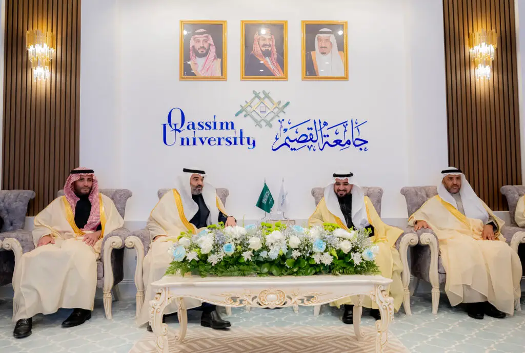 يجلس أربعة رجال يجلسون على الشماغ السعودي أو الغترة السعودية على مقاعد فخمة في جامعة القصيم، وتوسطهم باقة من الزهور، وتعلوهم صور لعدم المملكة العربية السعودية، في مشهد يجسد دور الجامعة بالكامل ضمن عناصر البحث فقط.