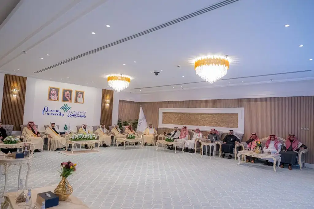 اجتمع عدد من الناس، ودعا المجموعة الغترة والعقال والبشت السعودي، عندما دعا إلى البدلة الرسمية، في قاعة الرقص الواسعة في القصيم. وتبرز في القاعة المصباح واللوحات التنظيمية وشعار الجامعة الرسمية. التأكد من وجودهم حول البحث عن أسماء الجينات ودلالة أهمية والمكان.