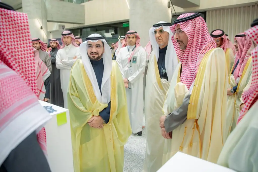 يتجمع عدد من الرجال بزيهم السعودي التقليدي في إحدى القاعات الداخلية، ويرتدي الاتفاق البشوت ثياب الثياب والسترة أو الشماغ السعودي. يجتمعون بجانب طاولات بيضاء ويتبادلون الأحاديث حول موضوع الصناعة والتعدين، في حين يقوم التنسيق بمتابعة النقاش في الخلفية.