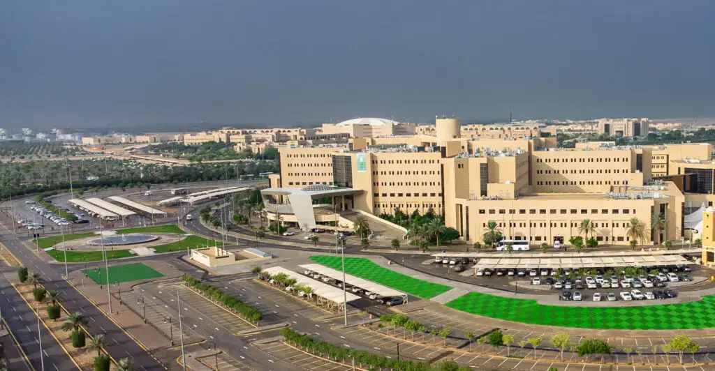مجمع مستشفى كبير باللون الأبيض، يُشكل جزءًا من المدينة الطبية، ويشتمل على ألف من عدة مبانٍ مُنفصلة مواقف سيارات ومساحات خضراء منسقة، للتعرف على شبكة من الطرق. يقع هذا المجمع وسط بيئة صحراوية تحت السماء يكسوها الغ بعضيوم.