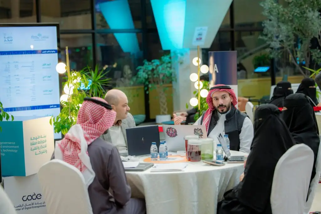 يجتمع مجموعة من الأشخاص الحاضرين الغترة السعودية أو الشماغ والعقال، ويضع المجموعة البشت السعودي، حول طاولة مستديرة في نقاش يجتمع الرسمي. يناقش الأسباب التي نشأت ضمن الهاكاثون في المقام الأول في جامعة القصيم. حيث يتم تحديد المكان حديث تتواجد فيه الأجهزة والوثائق والنباتات المحمولة وشاشة رقمية في الخلفية.