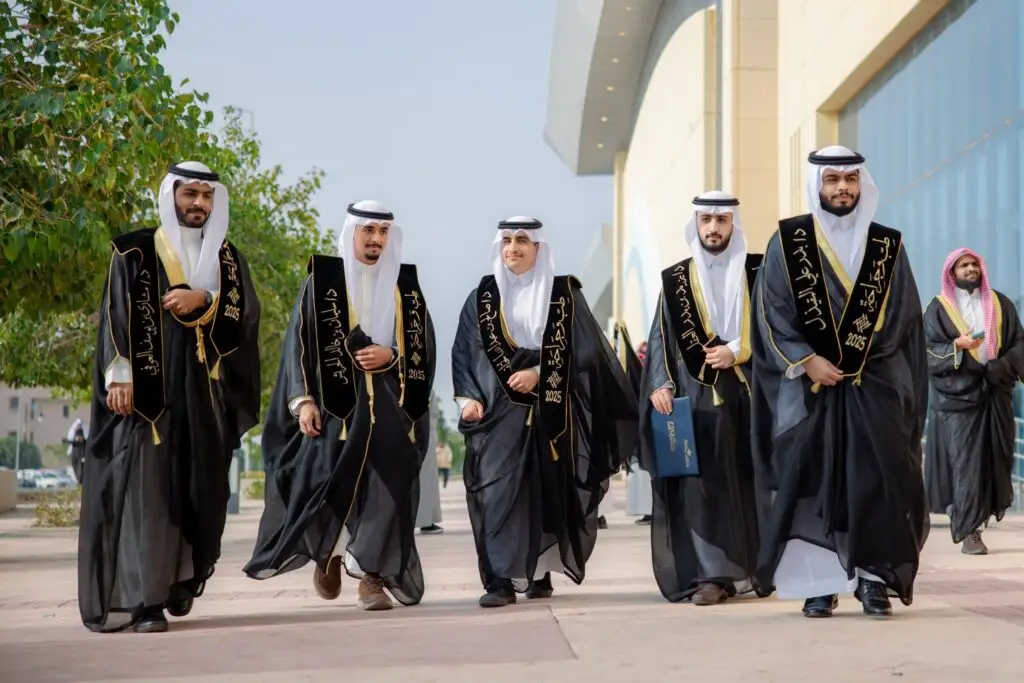 خمسة رجالٍ أولد الزي السعودي الأصلي مع الشماغ أو الغترة السعودية، بالإضافة إلى عذراء التحرير، سيشون خارج جيل جديد عقب تخرجهم من الجامعة، المتضررين مبتسمين ومسترخين. ويلحق بهم آخر يرتدي الزي. وتحيط بهم العناصر المتنوعة في خلفية صفاء السماء.