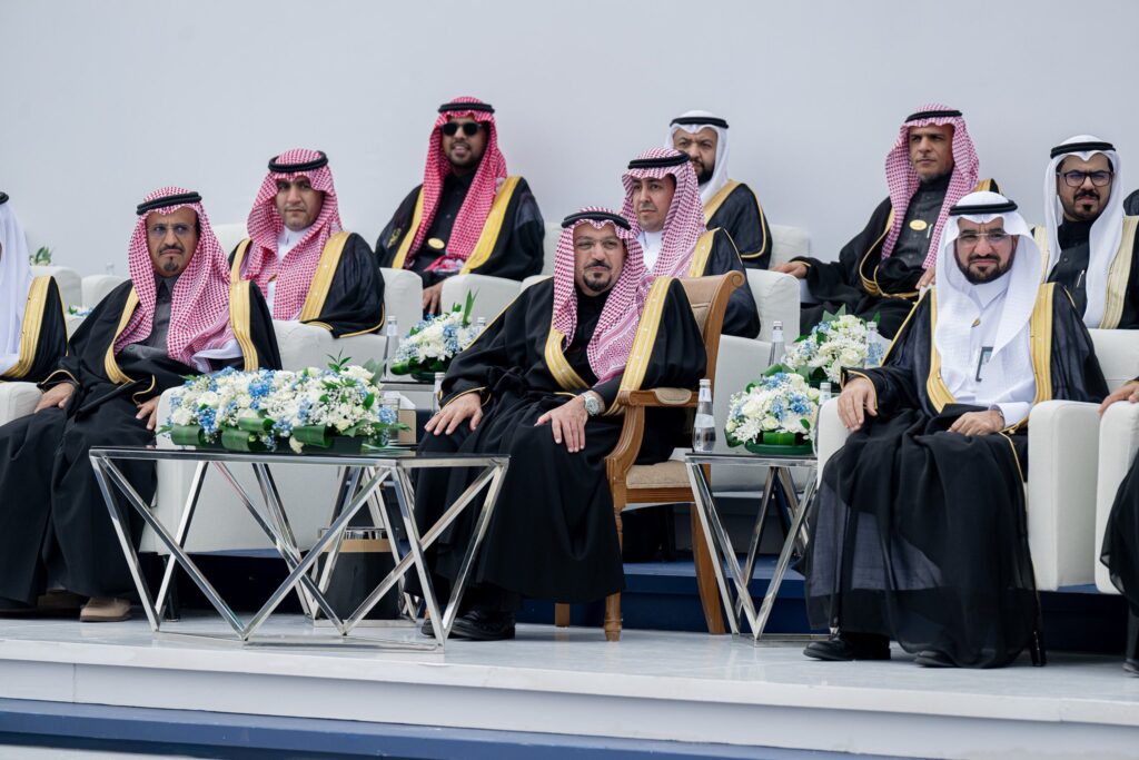 يجلس مجموعة من الرجال مرتدين الزي السعودي التقليدي الذي يتكون من الغترة أو الشماغ، والعقال، والبشت السعودي، ومن بينهم أمير منطقة القصيم، على كراسٍ باستثناء خلال أول بنيتها جامعة القصيم. وتتوسطها الجداول تحمل تنسيقات تنسيقية جميلة، بينما تظهر في جدار أبيض بسيط يعكس الخلفية الرسمية.