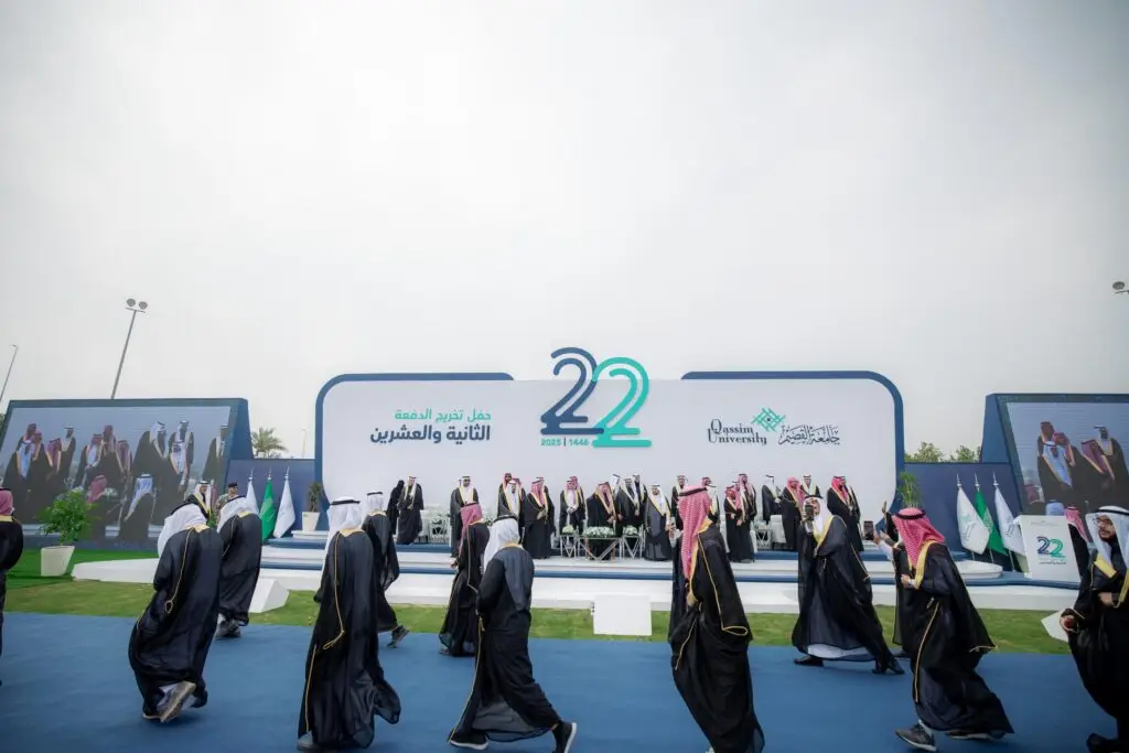 ويذكر مجموعة من الأشخاص الزي السعودي الرسمي، بما في ذلك الشماغ أو الغترة السعودية، أمام مسرحية في التخرج الخارجي. ينصح على منصة البناء أرقام كبيرة (22) ونص عربي عصر اسم "الجامعة" ويكرّم "الخريجين"، وذلك ضمن فعاليات جامعة القصيم.