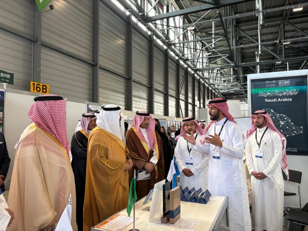 يتجمّع عدد من الرجال مرتدين الغترة السعودية والعقال والبشت التقليدي حول جناح خاص في القصيم في إحدى قاعات المؤتمرات أو المؤتمرات الداخلية، حيث يستمتعون باهتمام بمقدم الجناح. ويبرز في الجناح وجود الأعلام التي تعتبر رمزية إيمانية بالجامعة ورسالتها الأكاديمية.