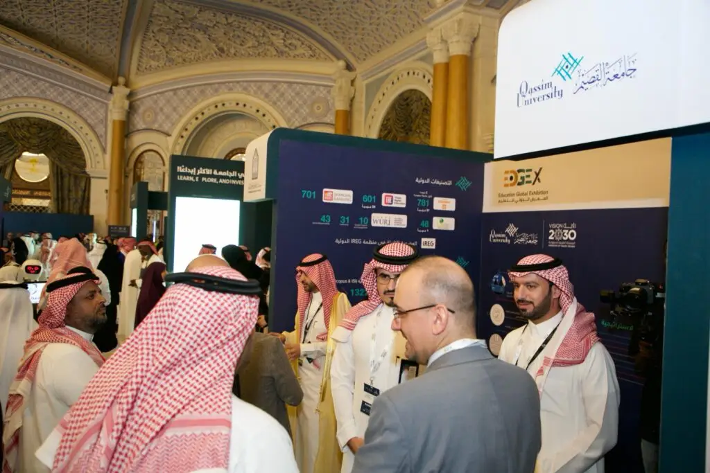 يجتمع عدد من الرجال، ويتشكل معظمهم من الغترة أو الشماغ والعقال بالإضافة إلى البشت السعودي التقليدي، للحوار في أروقة المعرض الدولي للتدريب بالرياض. اقترح في كأس الفسيحة ذات الإبداعات الفاخرة أجنحة المعرض واللافتات التعريفية، من جناح جامعة القصيم وجامعات أخرى.